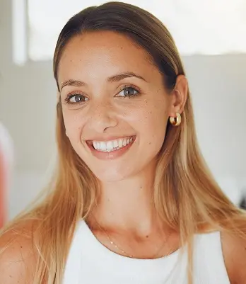 Smiling woman patient displaying healthy teeth after dental crown treatment in Mineola.