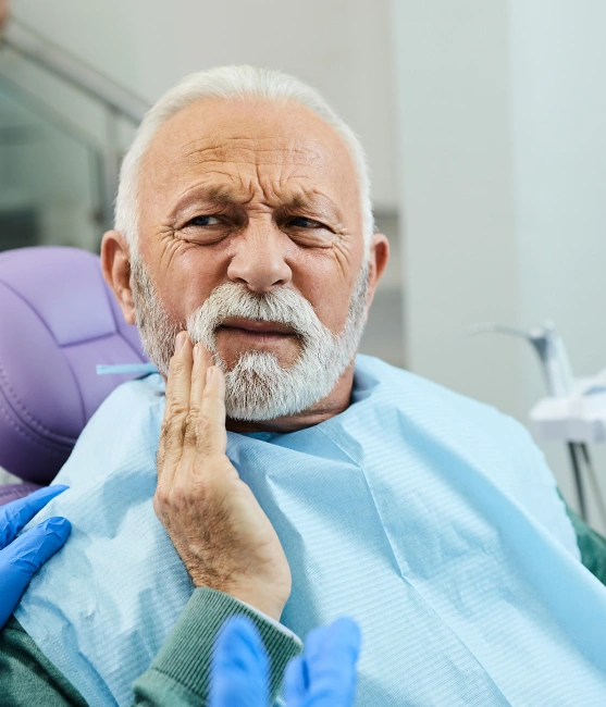Senior patient smiling during a tooth extraction consultation with a dentist